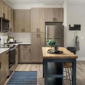 Settle into comfort at The Hudson a kitchen with wooden cabinets